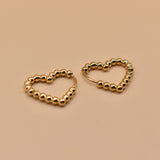 Gold heart huggies hoop earrings with charm design