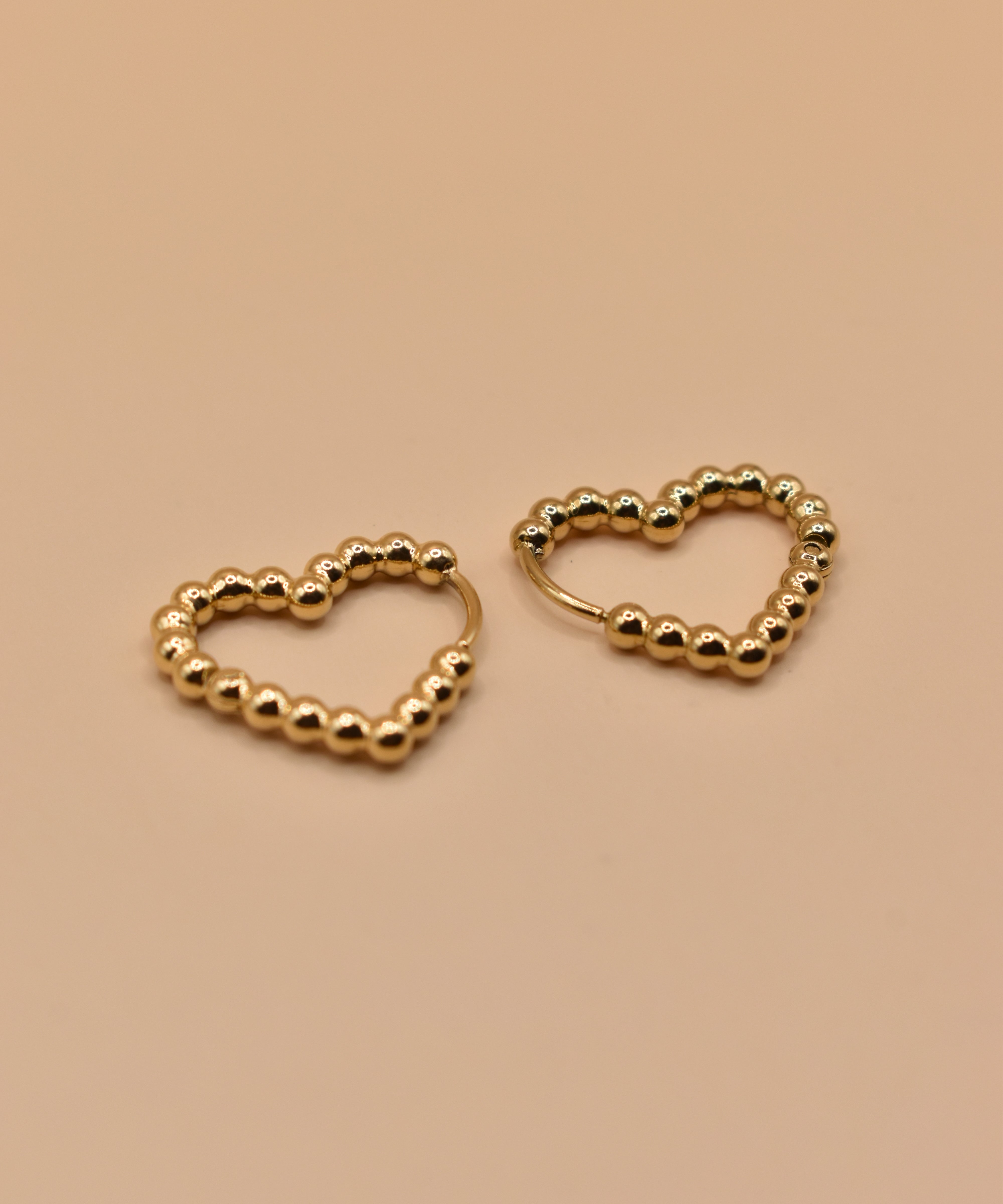 Gold heart huggies hoop earrings with charm design