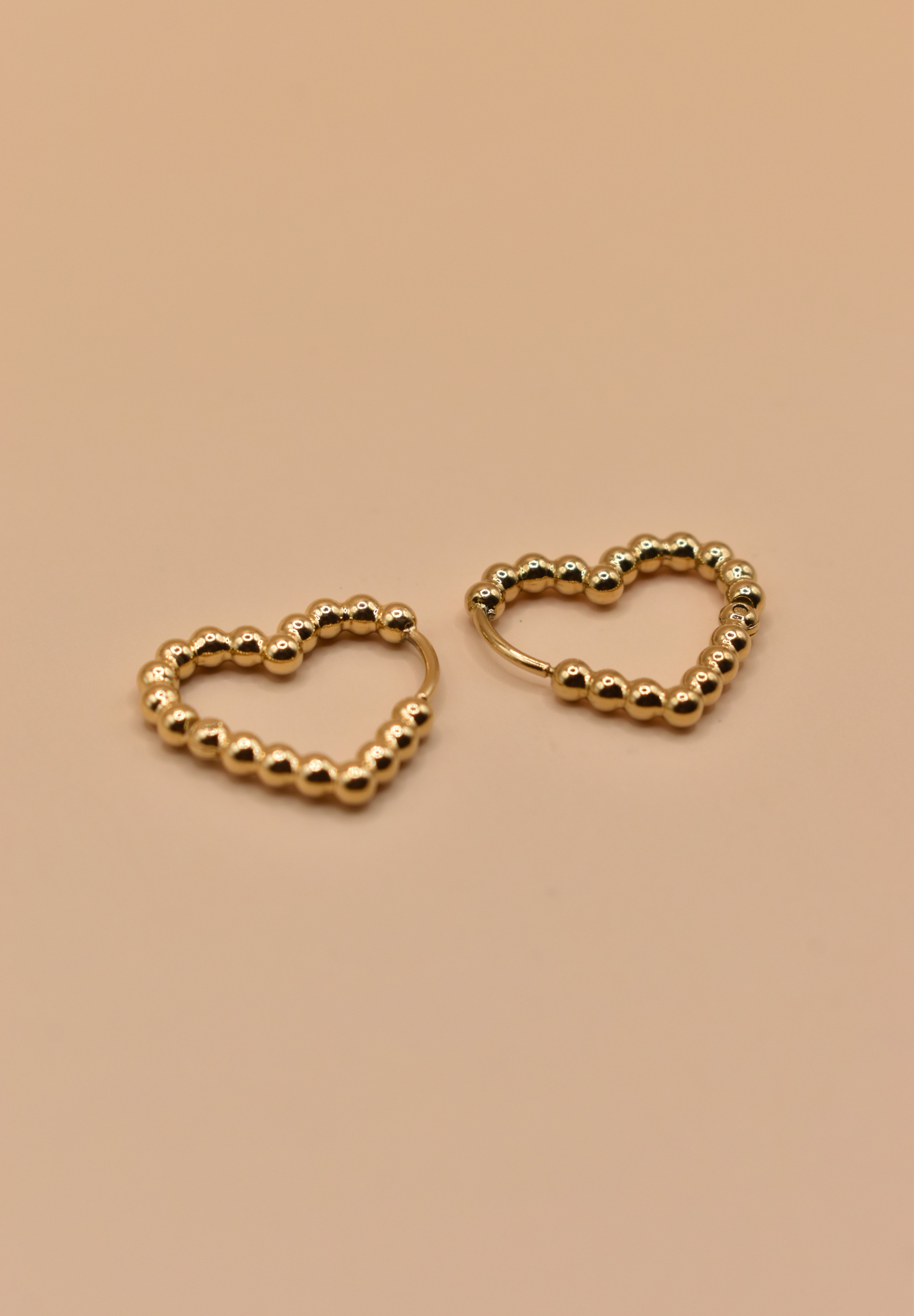 Gold heart huggies hoop earrings with charm design