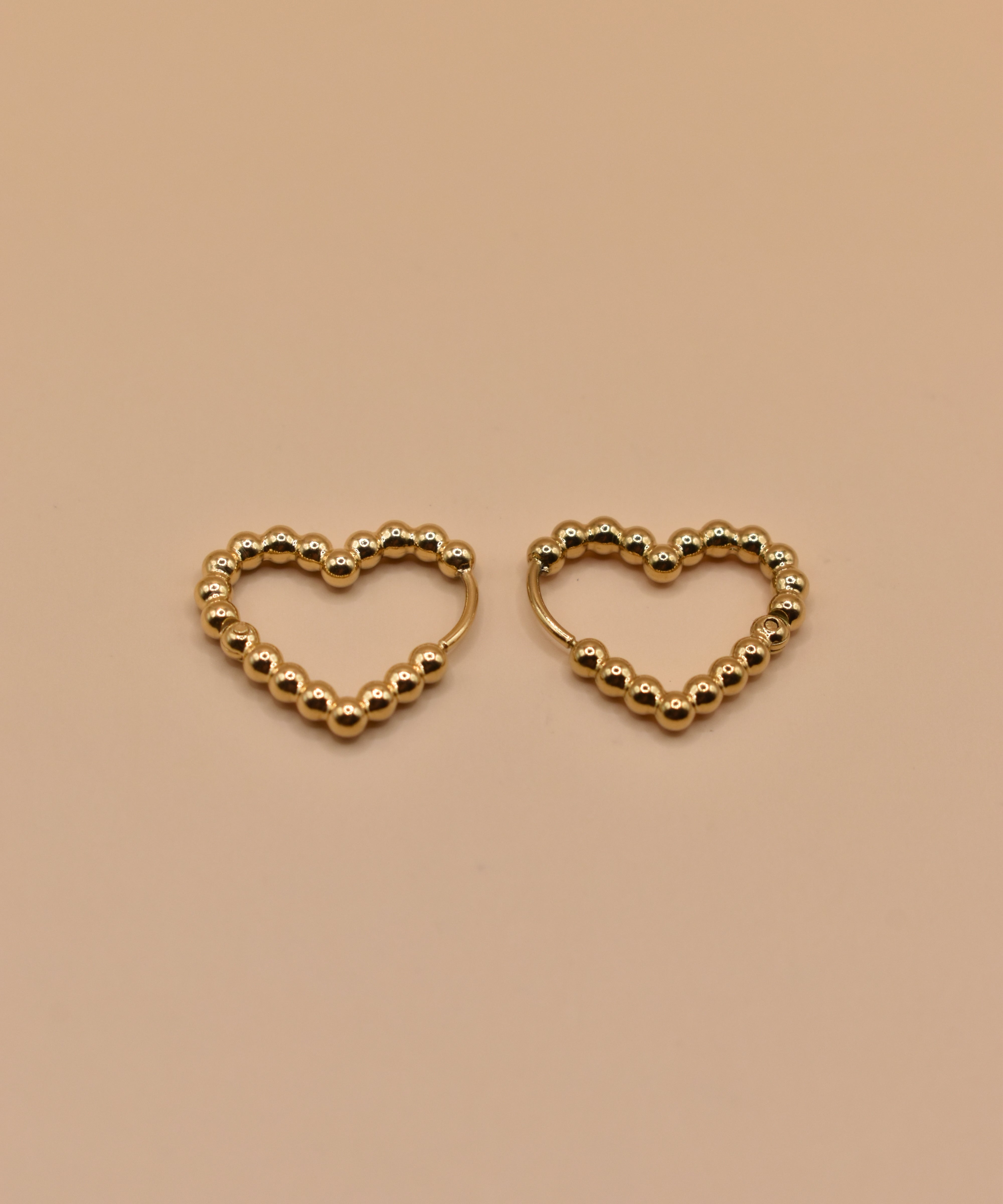 Gold heart huggies hoop earrings with charm design