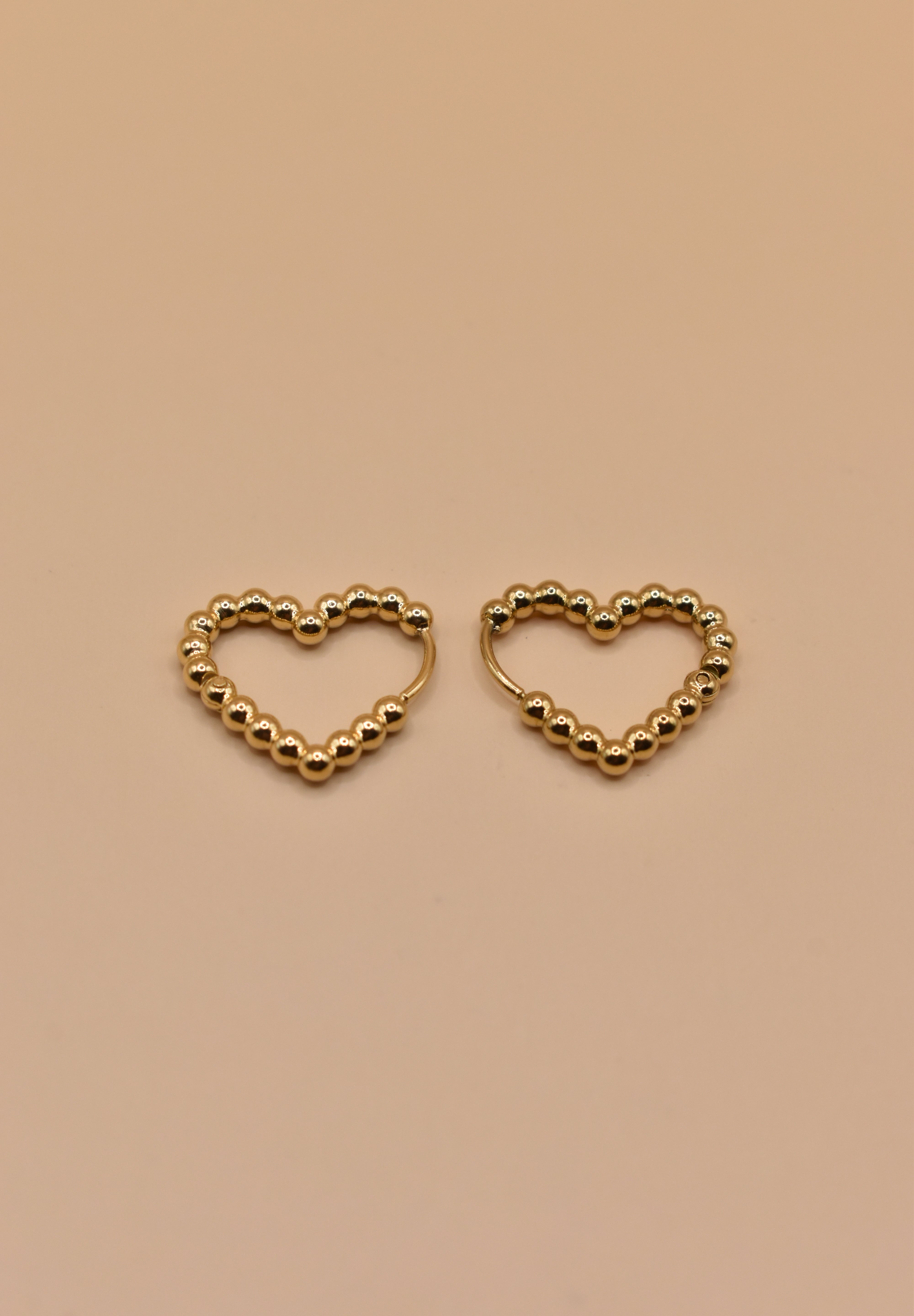 Gold heart huggies hoop earrings with charm design