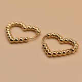 Gold heart huggies hoop earrings with charm design