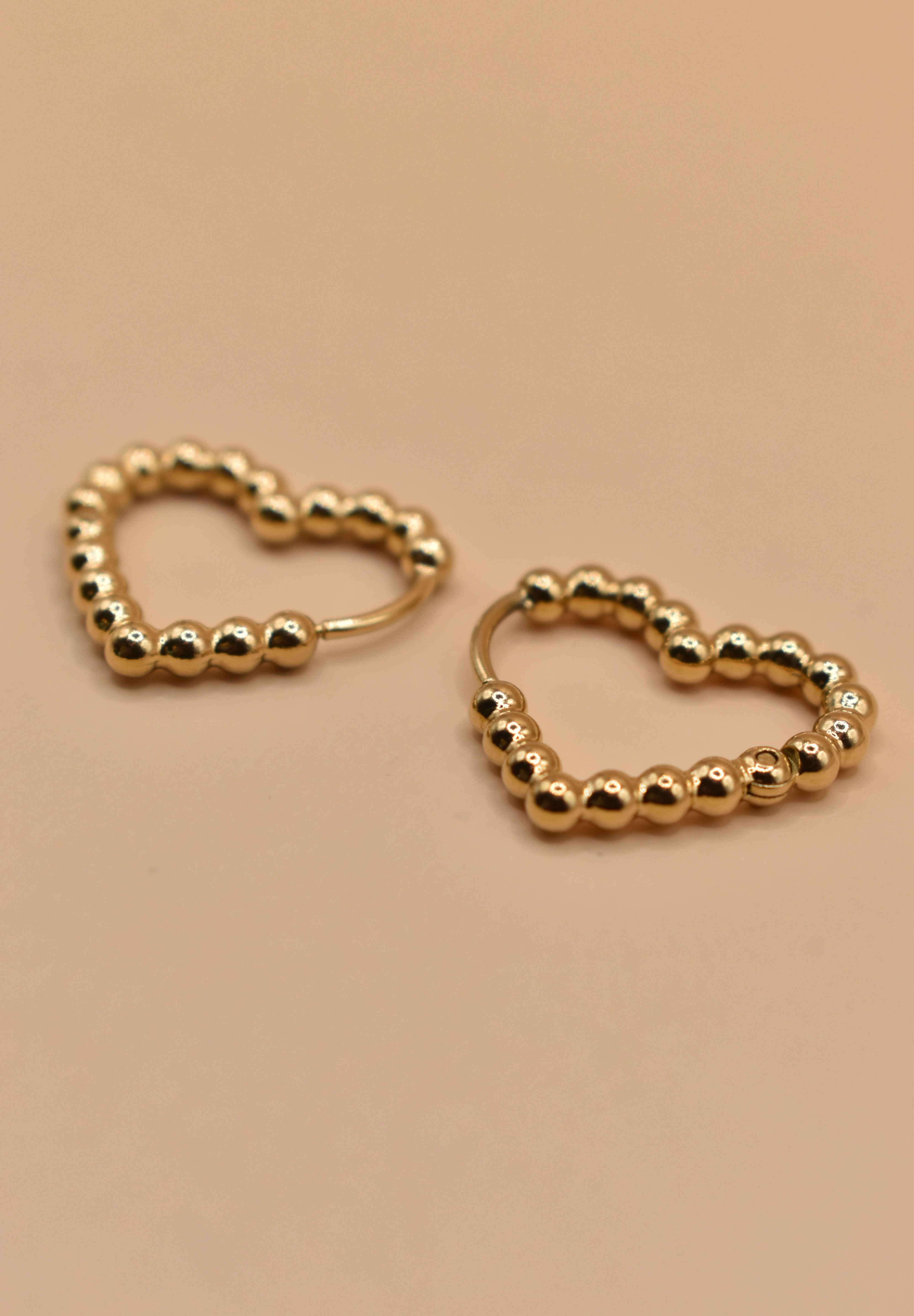 Gold heart huggies hoop earrings with charm design