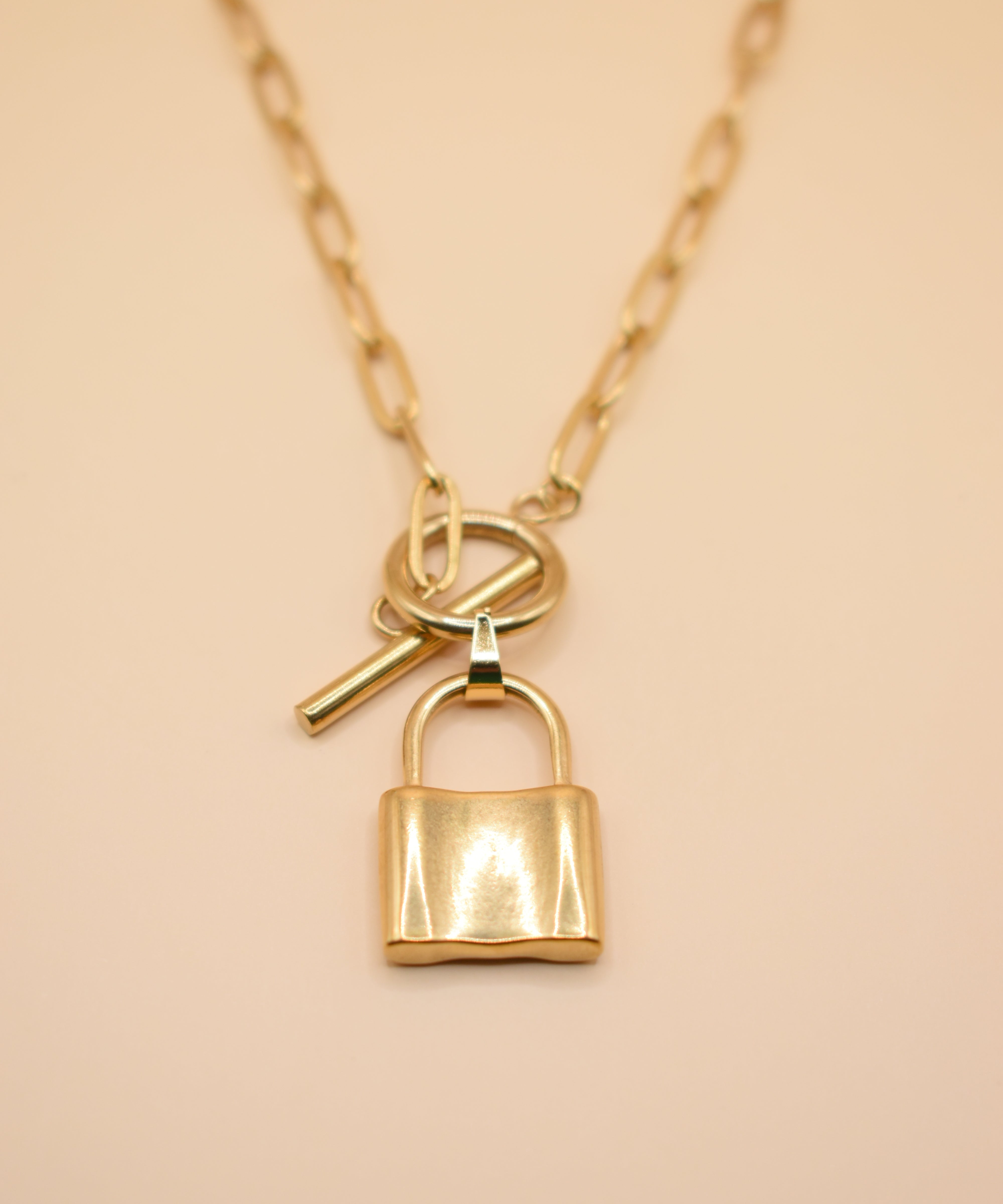 Gold lock pendant necklace on paperclip chain