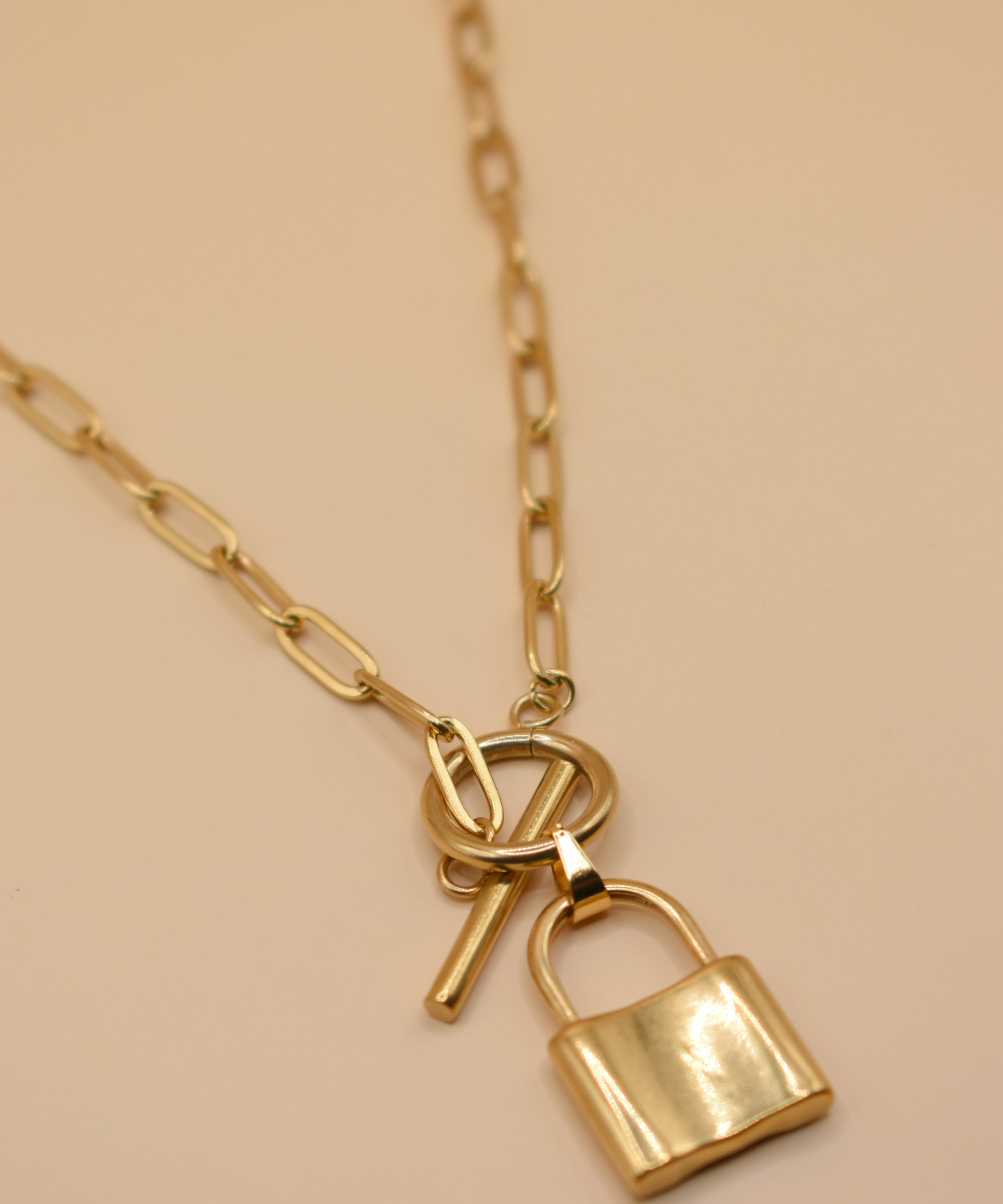 Gold lock pendant necklace on paperclip chain