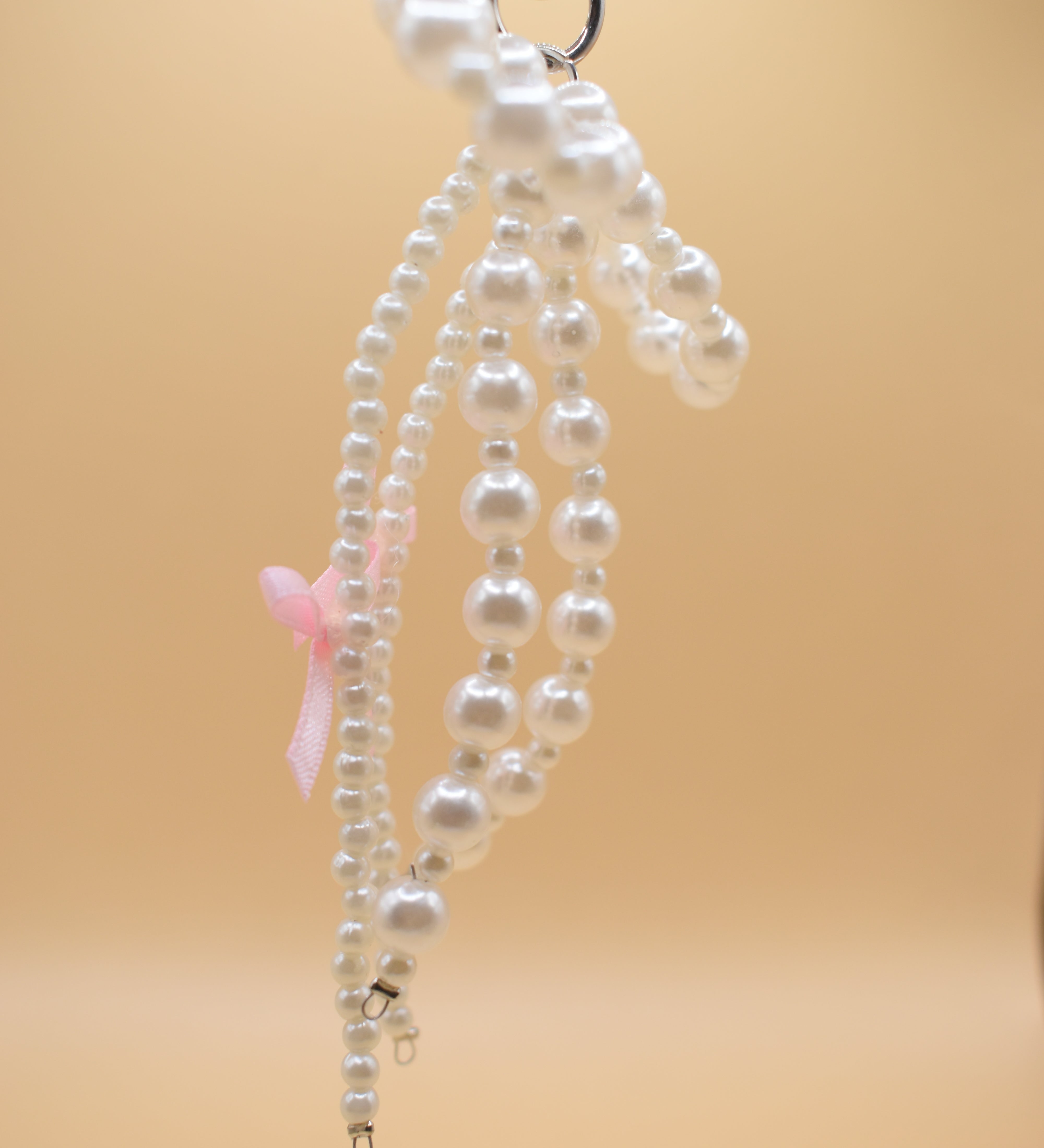 White pearl bow charm attached to gold purse clip