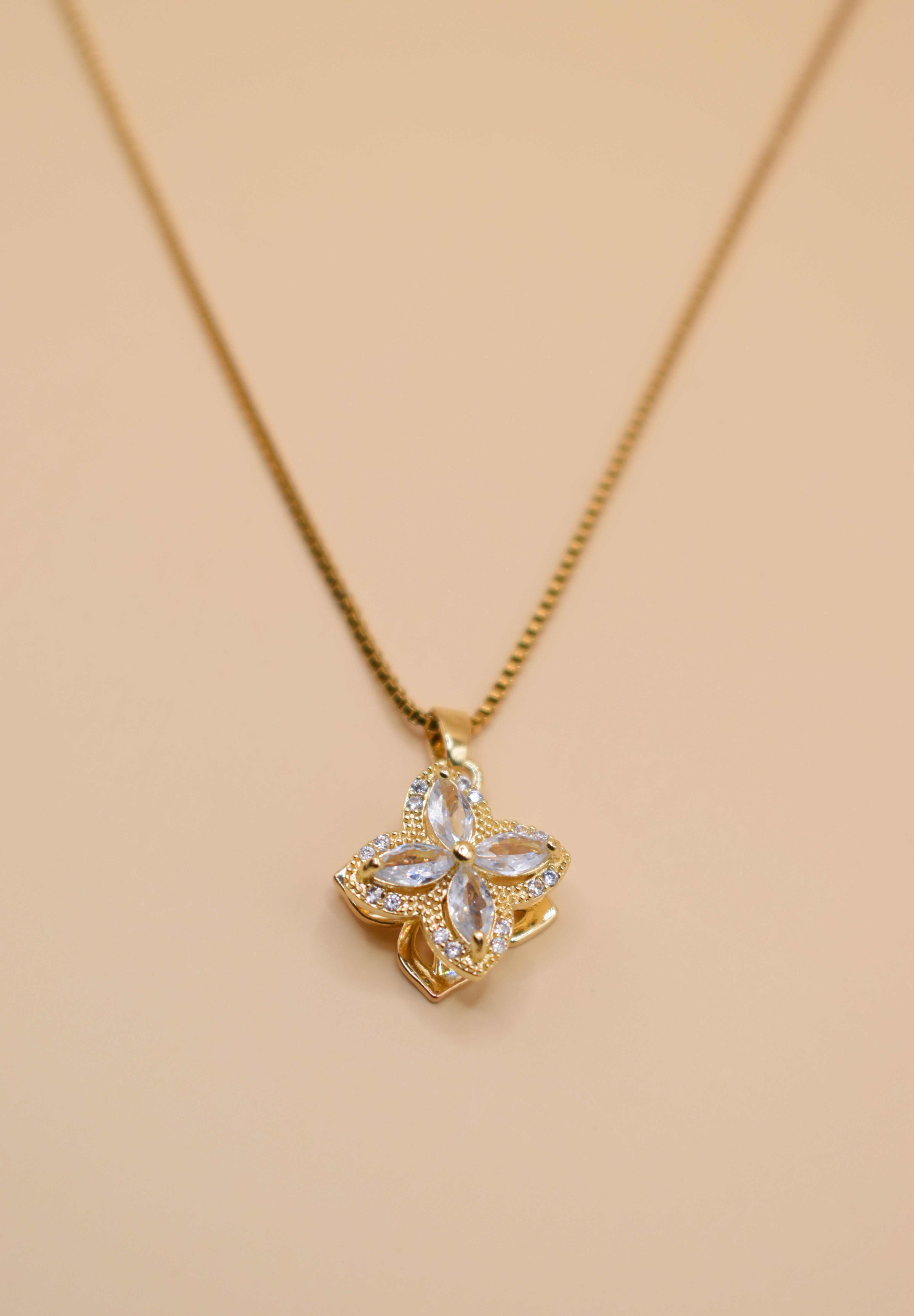 Gold clover pendant necklace with rotating charm
